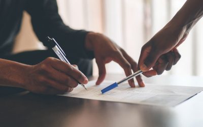 Cropped shot of an unrecognizable man filling a document with the help of a financial advisor at home