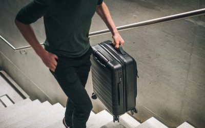 He carries a suitcase and walks up from subway platform