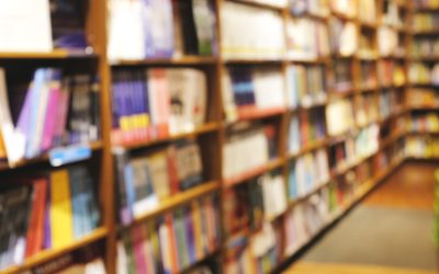 Blur background of book shelf store decorated with wood and warm light