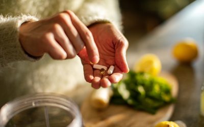 Close up of a Young woman taking a health supplement in the kitchen