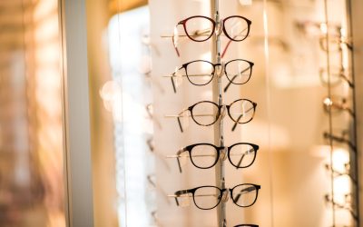 Large group of black eyeglasses at optician store.